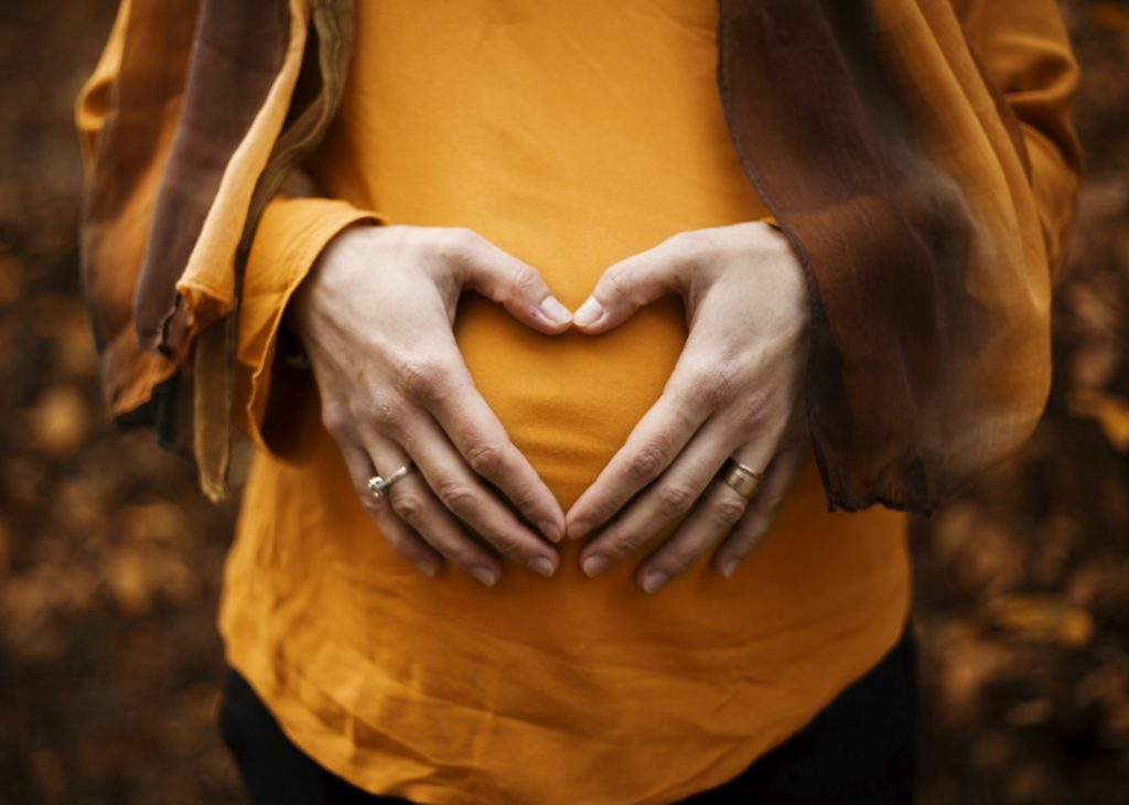 Expecting mother holding her baby bump